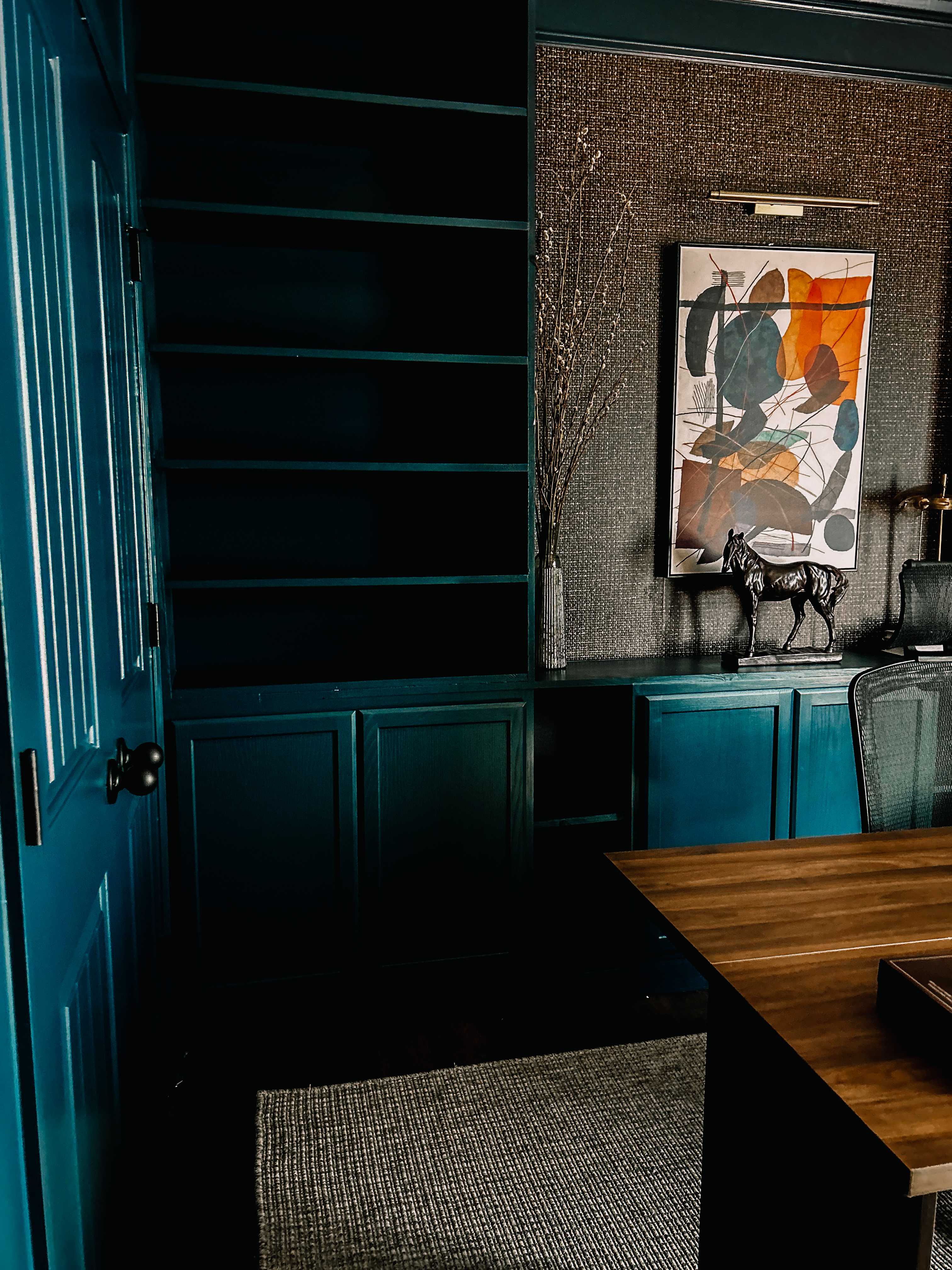 Teal office with grasscloth wall and abstract art
