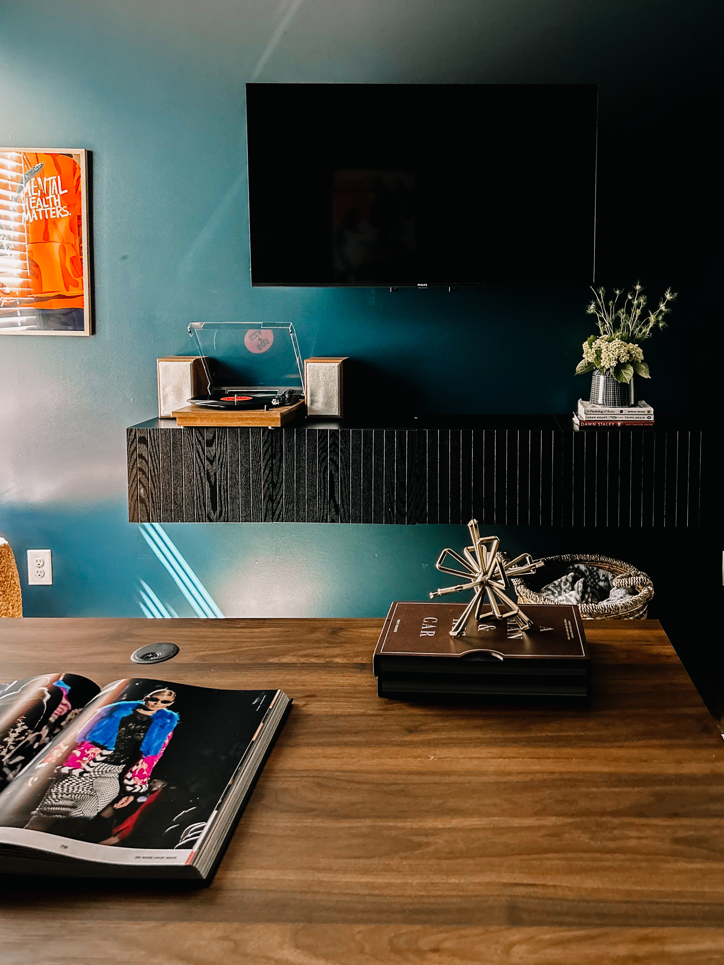 Turntable on floating console with TV and art above