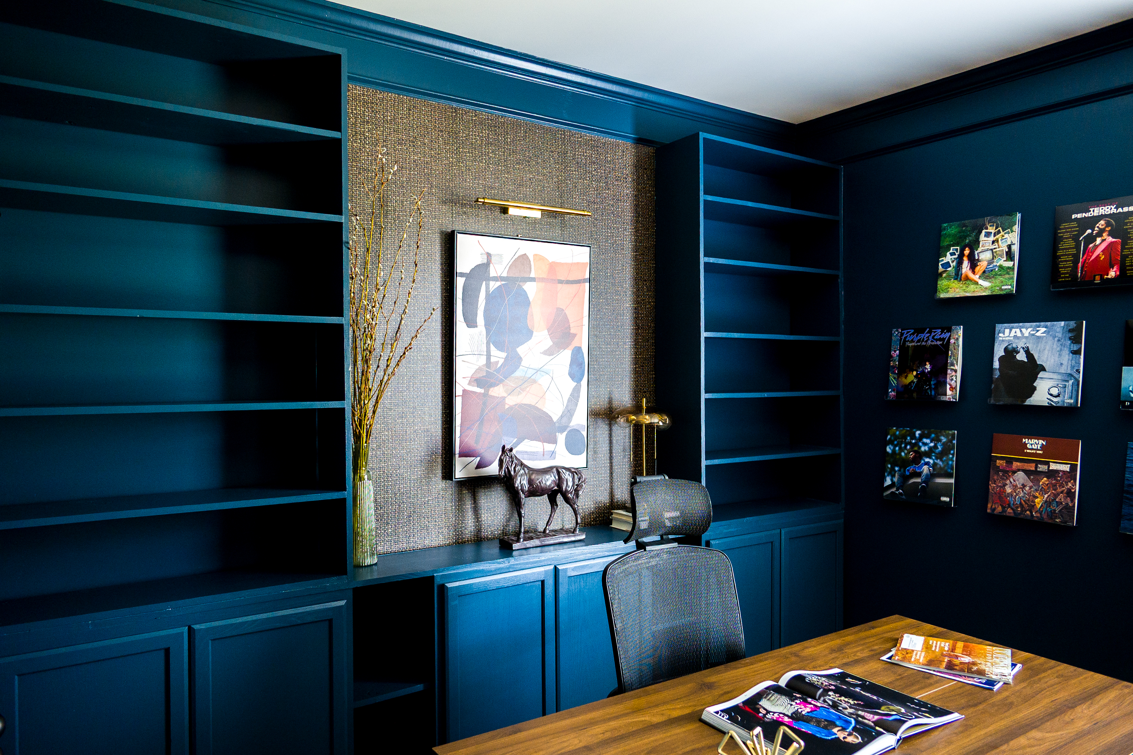 Built-in shelving, grasscloth accent wall, abstract art, and record gallery